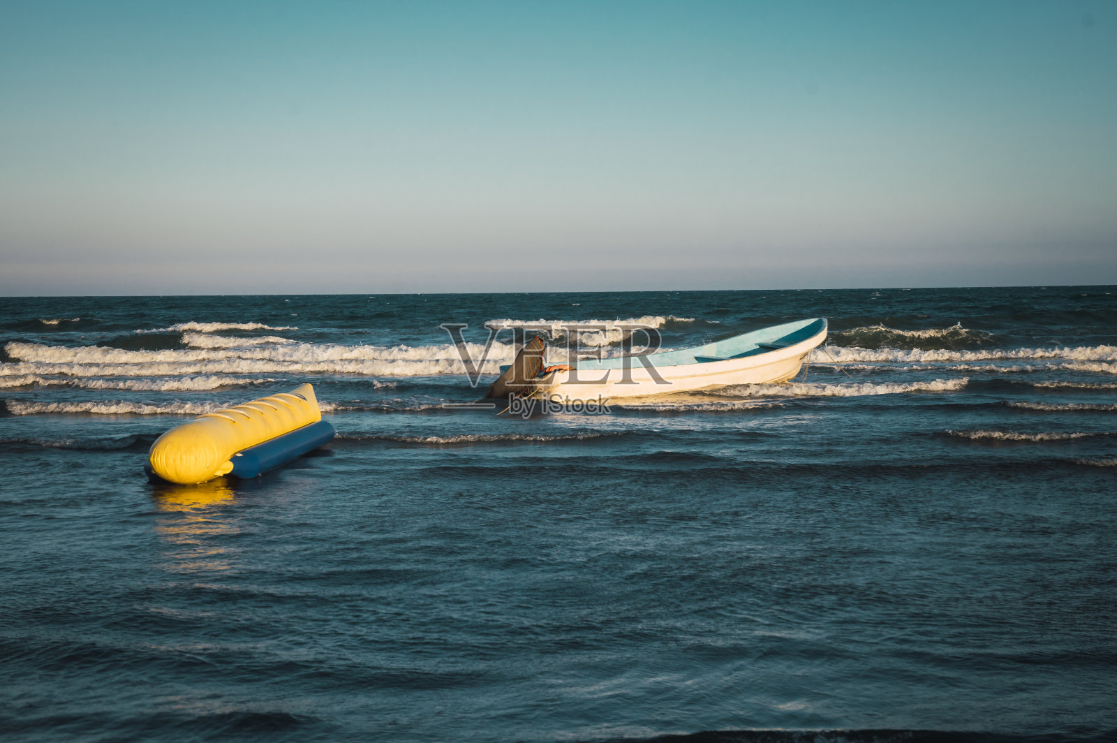 海浪上带有充气漂浮物的船照片摄影图片