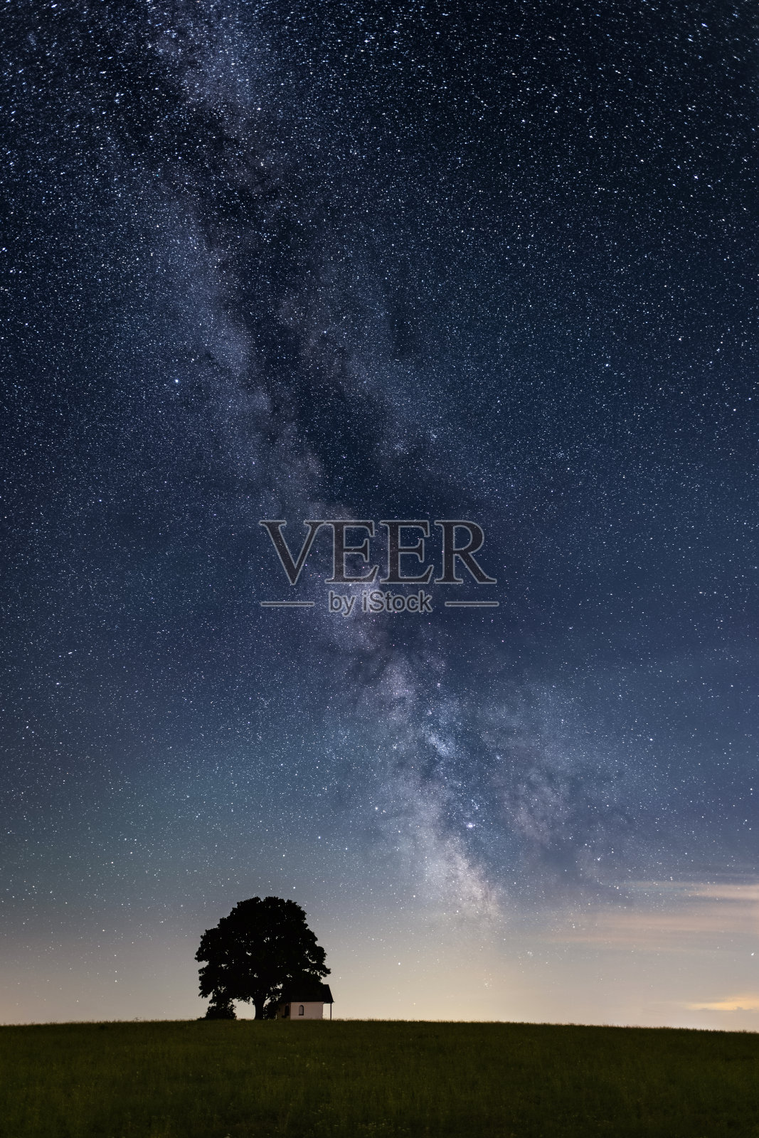 银河在一个有一棵小树的小教堂上方照片摄影图片