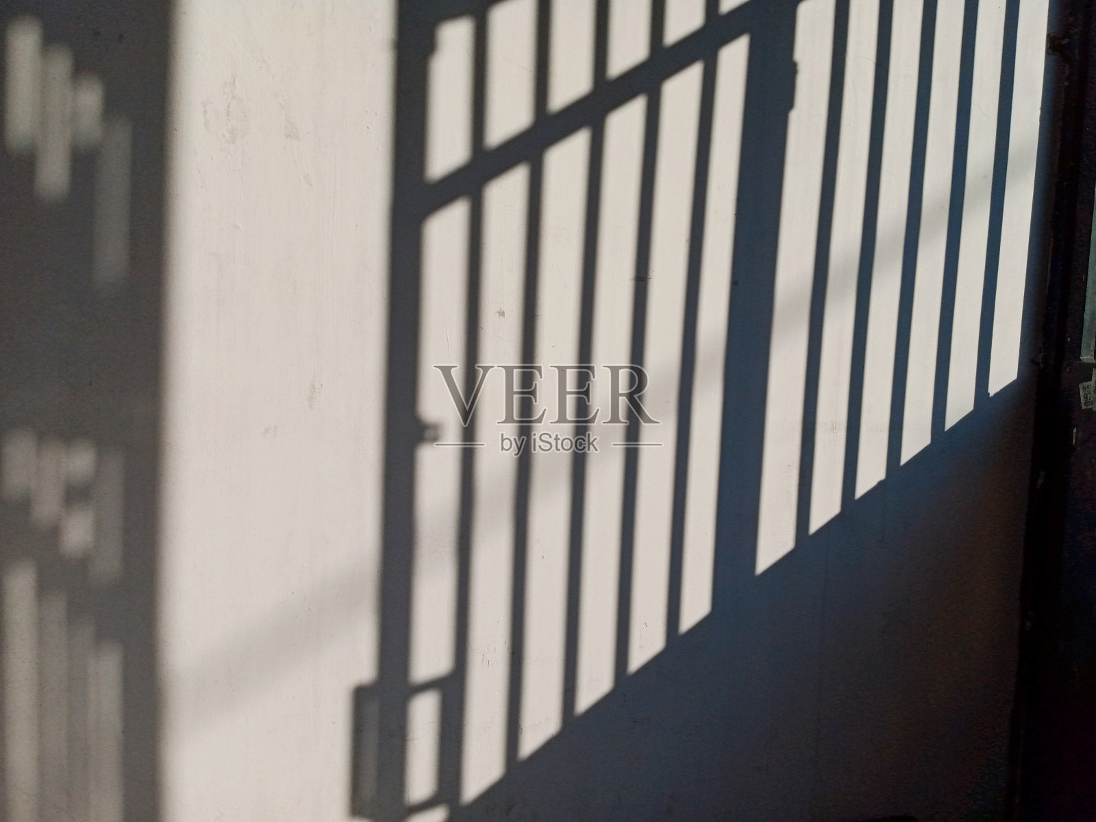 早晨的阳光从房子的篱笆上投下阴影照片摄影图片