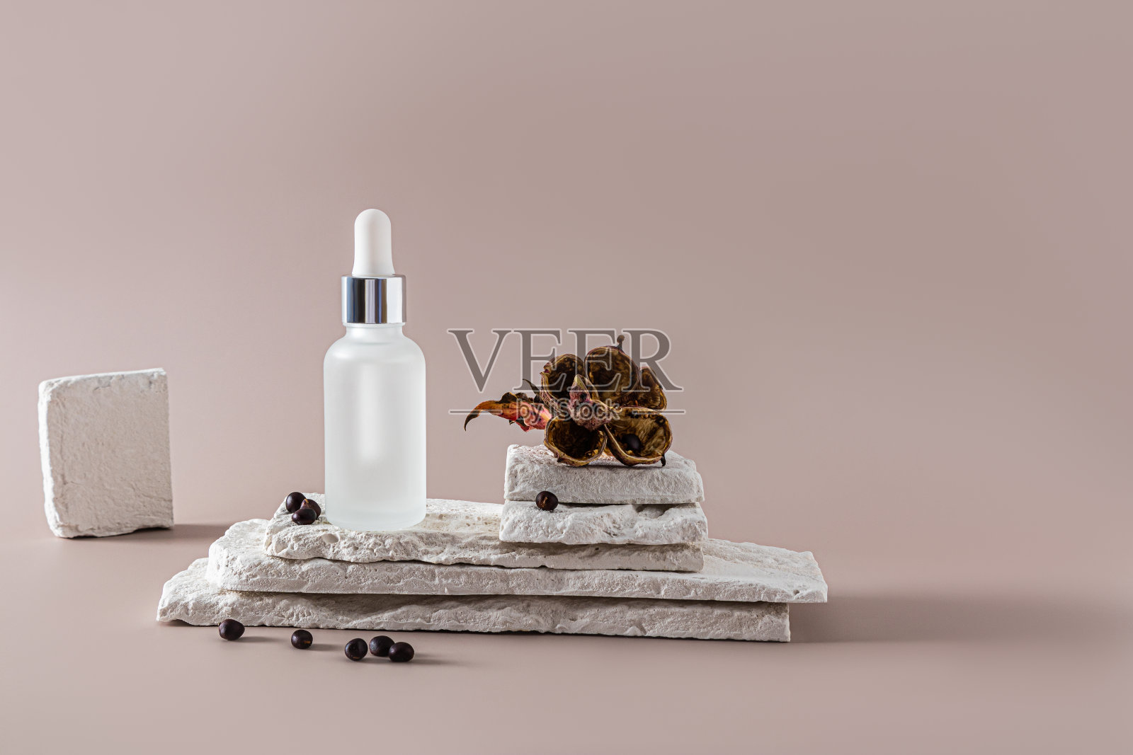 抗衰老化妆品在哑光瓶与滴管站在白石片与干牡丹花和种子。天然护肤。照片摄影图片