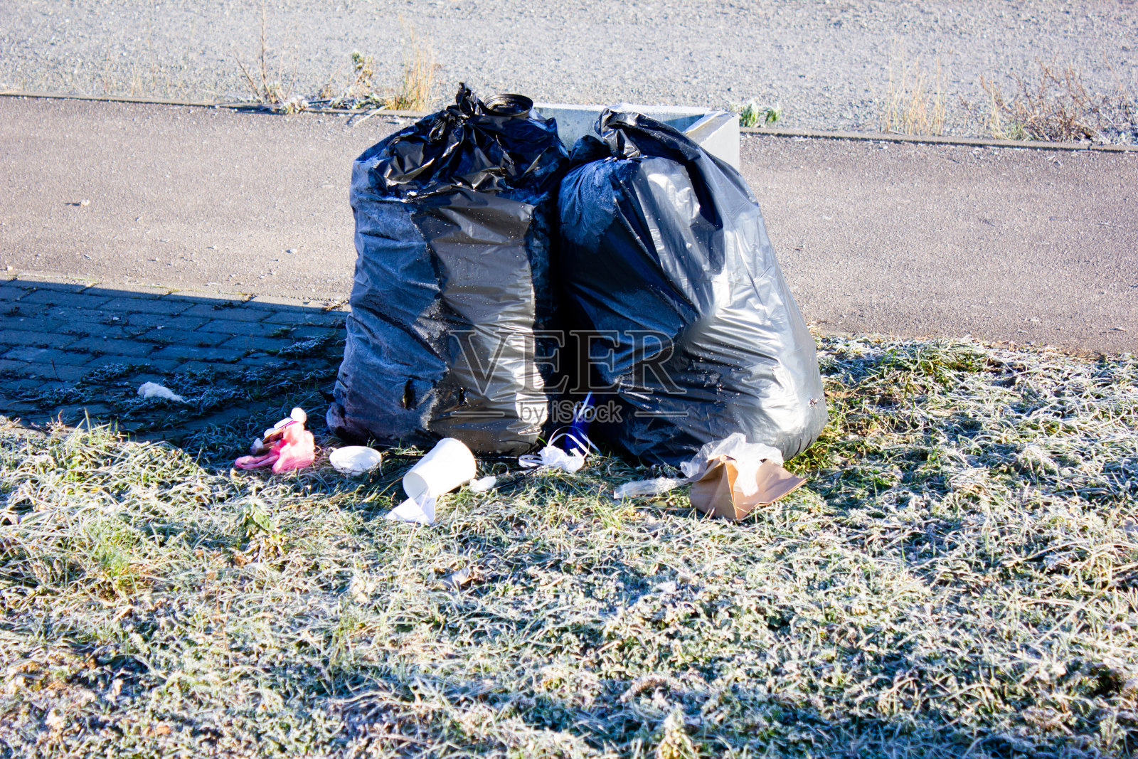 装有垃圾的黑色塑料袋。倾倒的袋子，袋子与垃圾，废物。照片摄影图片