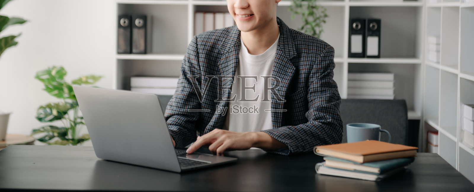 一个年轻人坐在办公室的办公桌前照片摄影图片