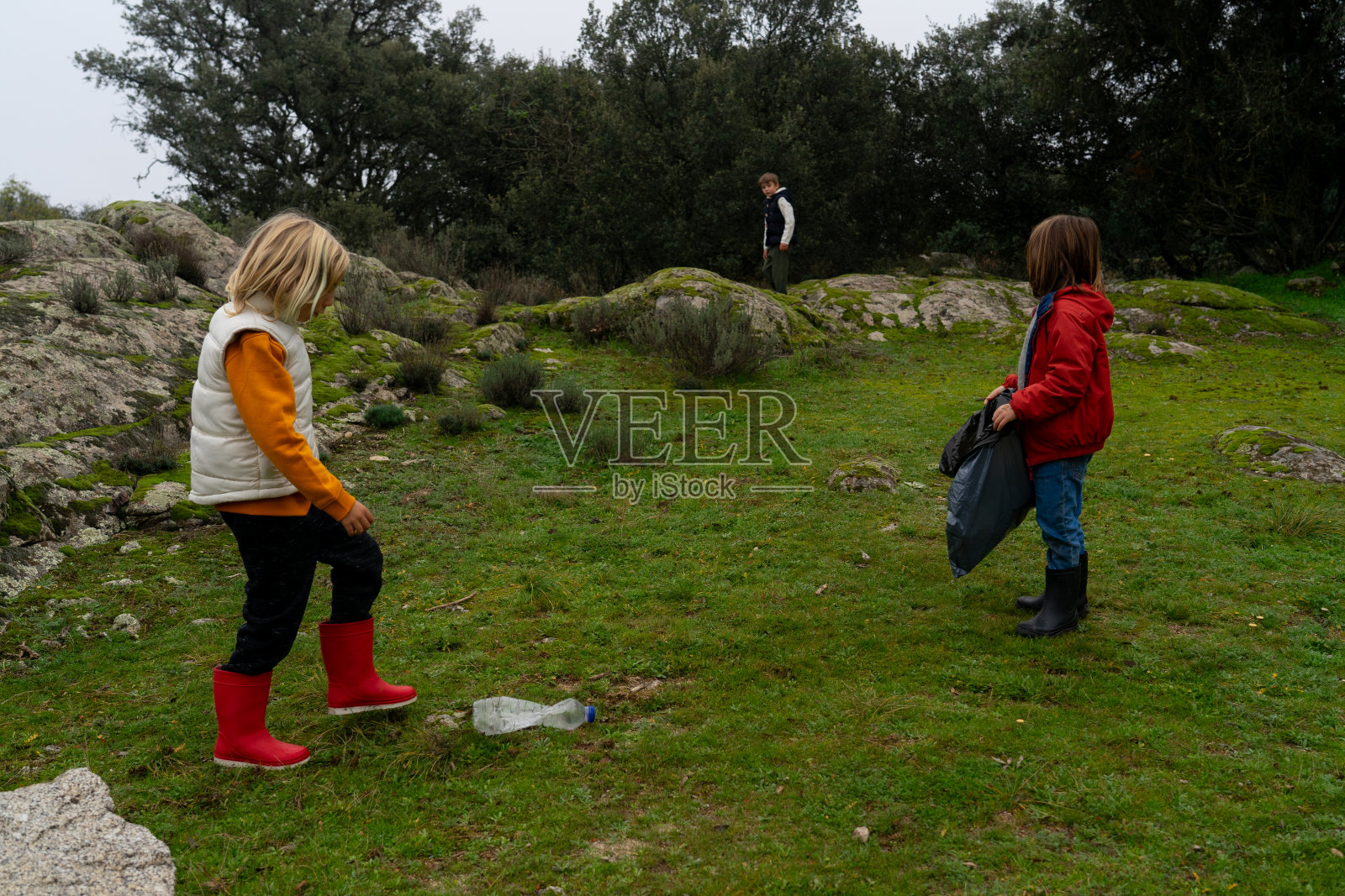 两个孩子从塑料中清理大自然照片摄影图片