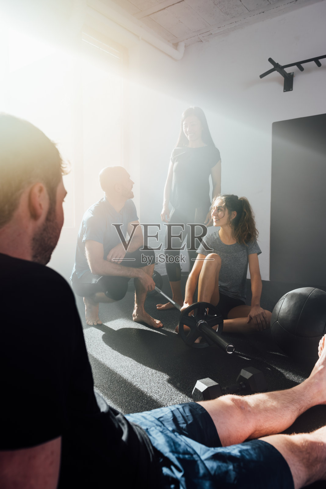 一群不同的运动员坐在体育馆里说话照片摄影图片