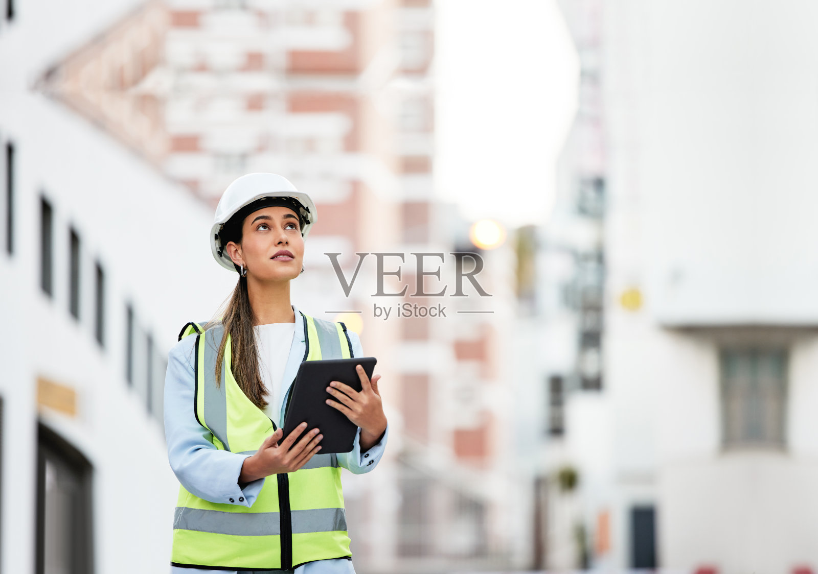 妇女，建筑和施工检查碑在现场工作的城市为工业。女性建筑师、建造者或承包商在检查触屏技术的建筑细节照片摄影图片