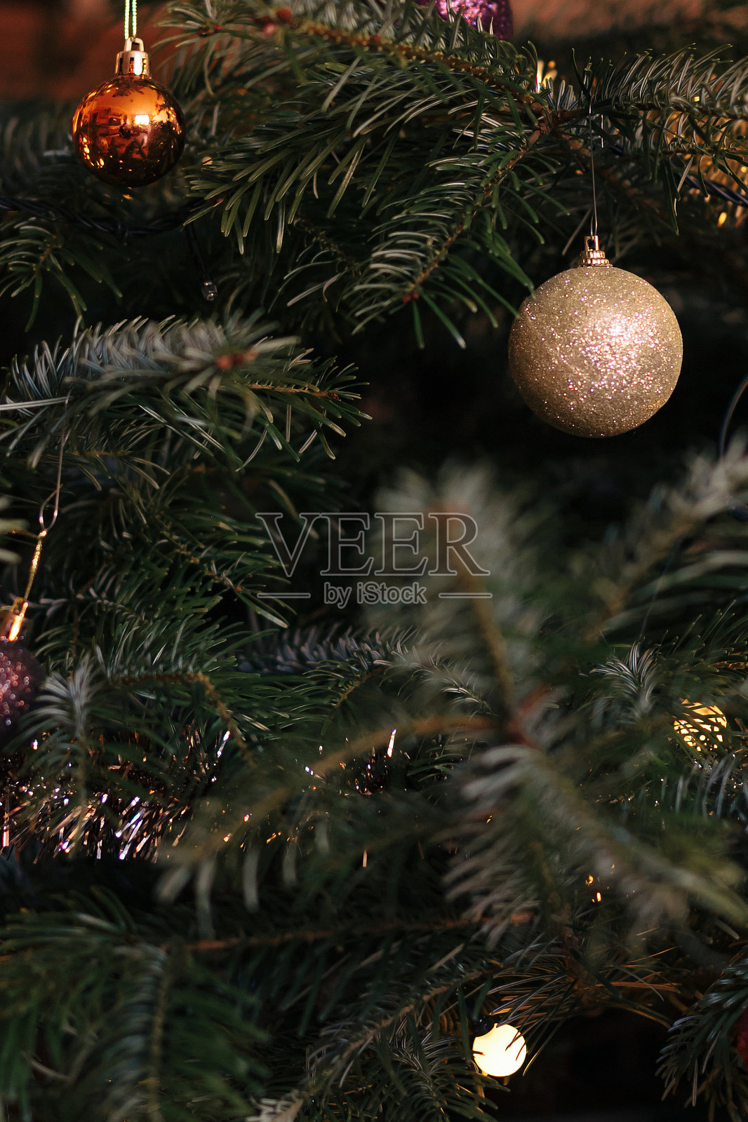 金色的新年玩具和花环挂在一棵天然的圣诞树上。特写和软焦点，圣诞和新年背景概念。照片摄影图片