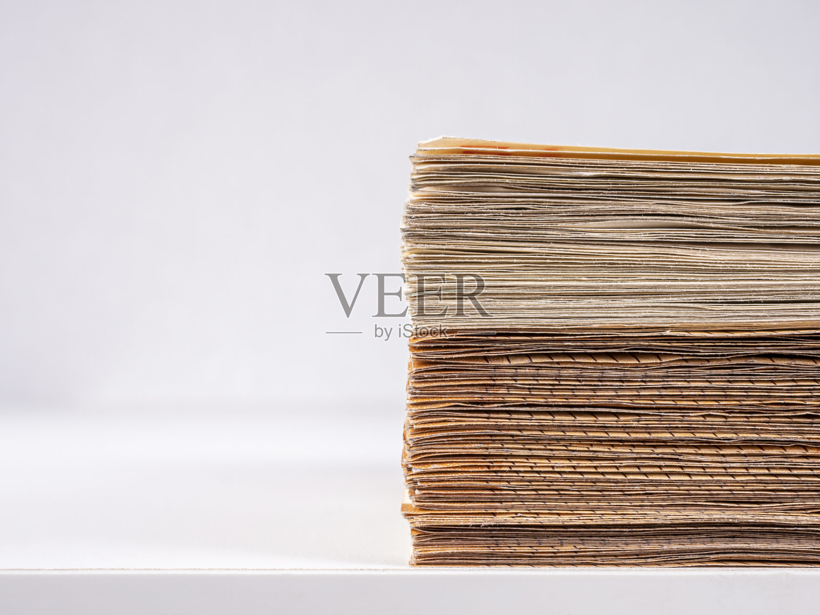 桌子边上有一叠欧元钞票，背景很浅。照片摄影图片