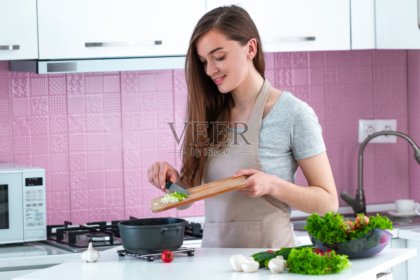 妇女在厨房用新鲜成熟的蔬菜做晚餐。干净的食物和健康的生活方式照片摄影图片