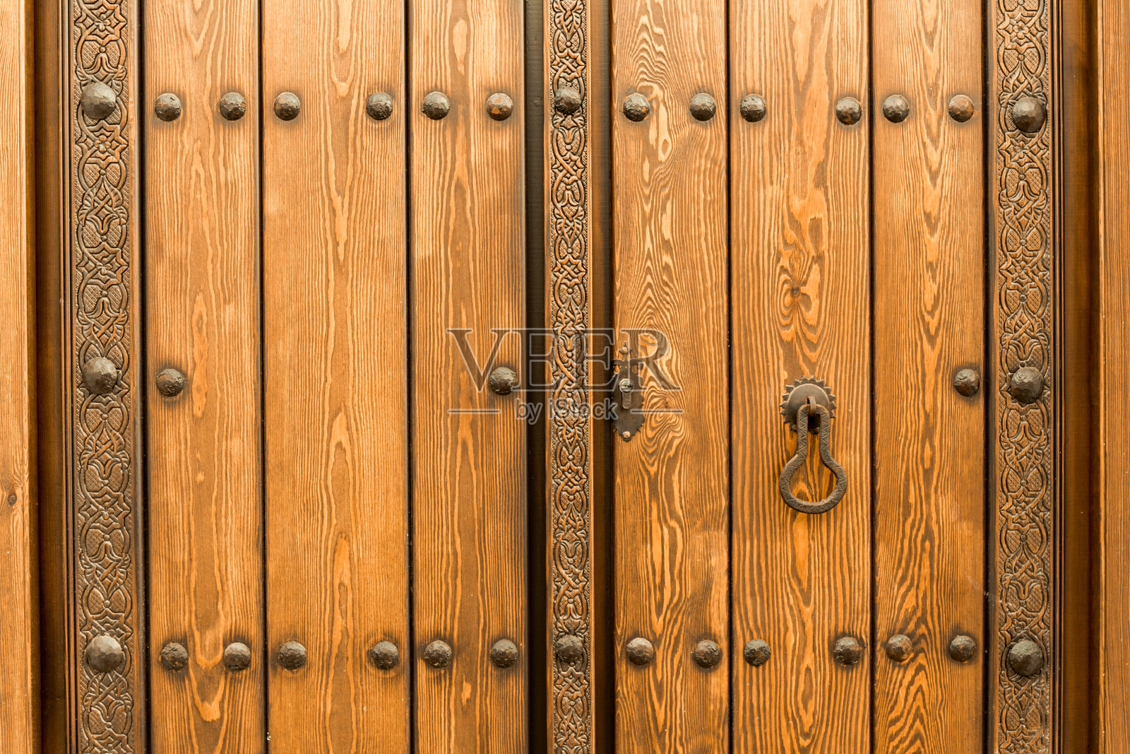 欧洲西班牙马拉加市一扇带有青铜装饰的中世纪木门近景照片摄影图片