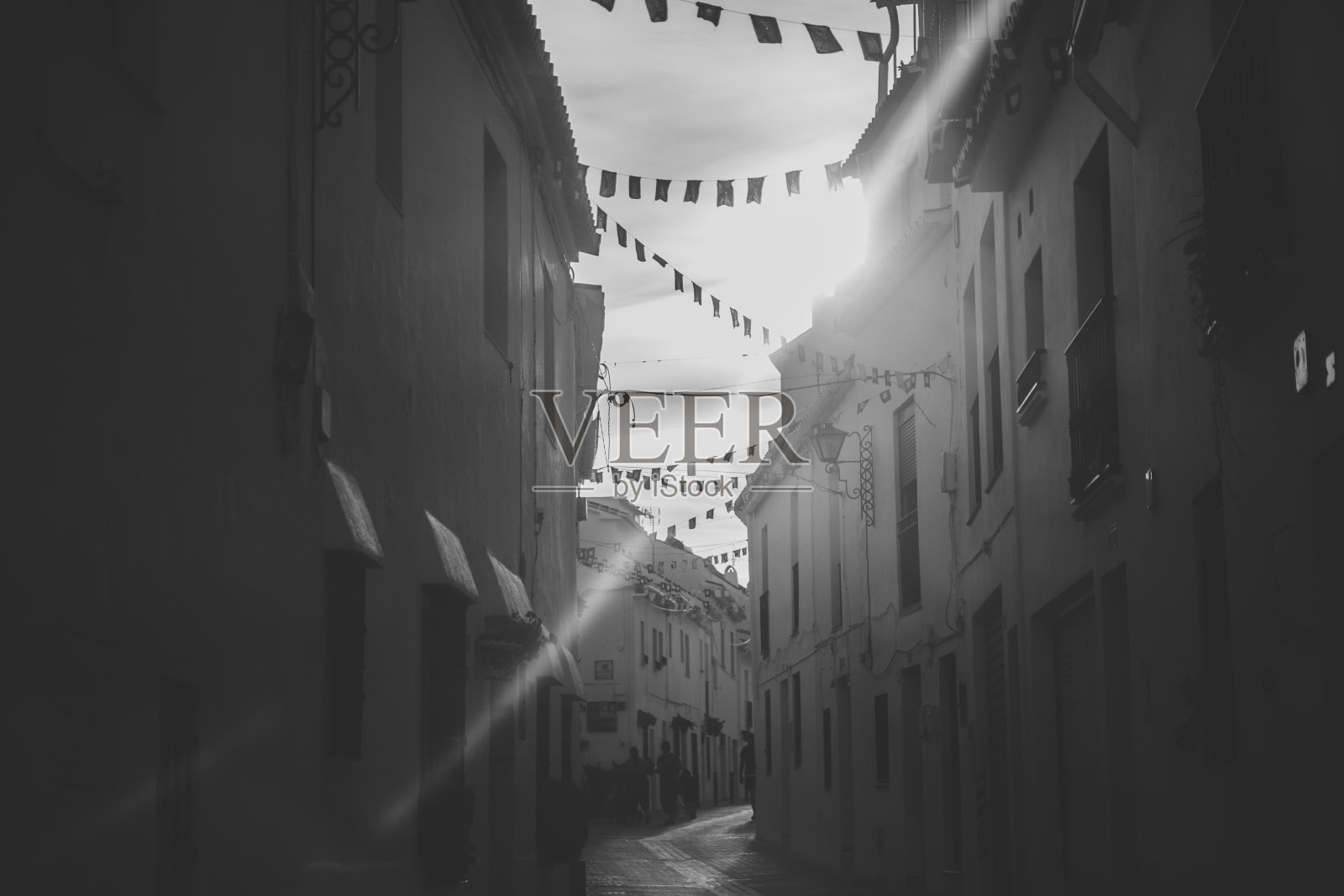 西班牙米哈斯市的黑白街头摄影，被旗帜装饰的中世纪小街道照片摄影图片