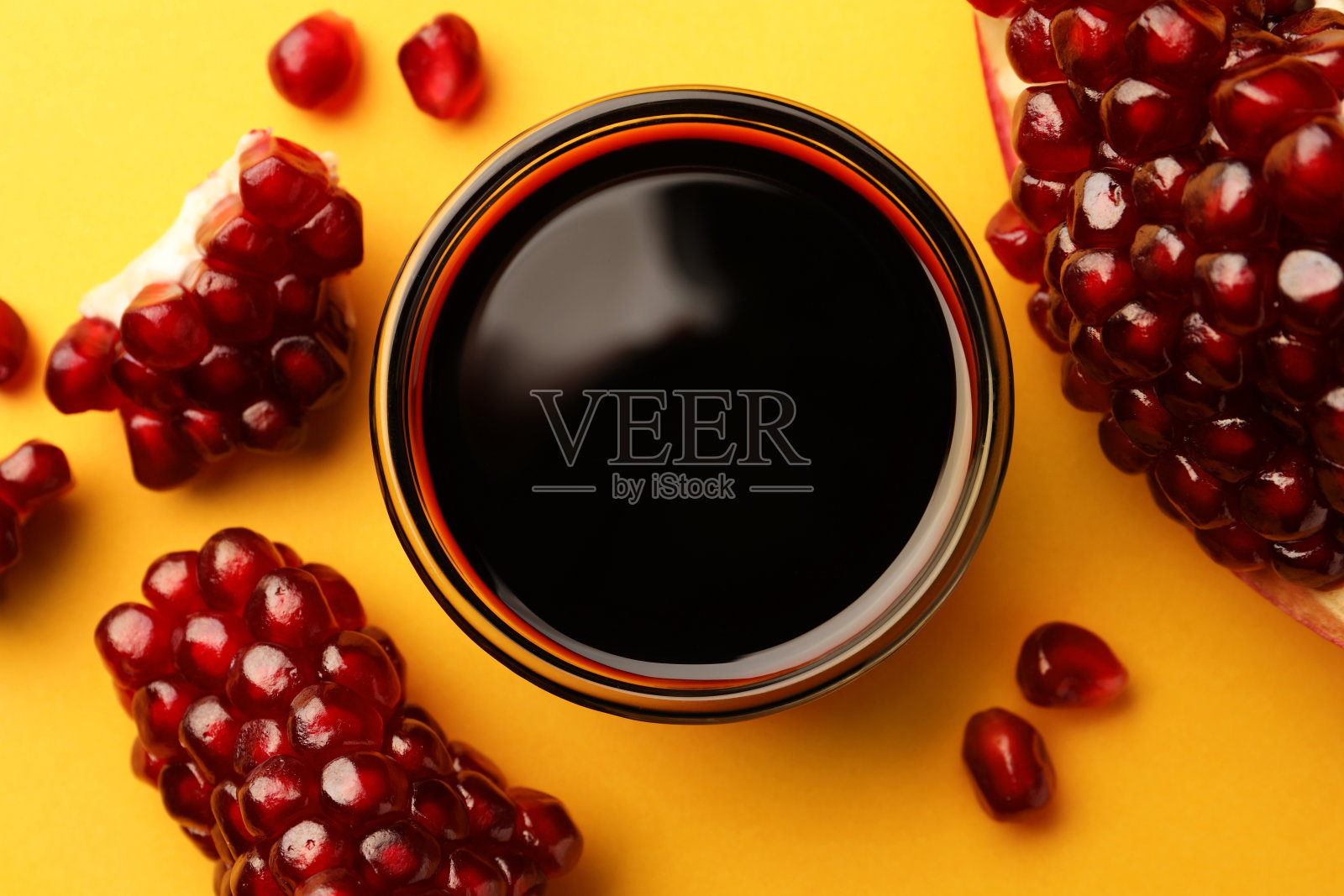 玻璃碗美味的石榴酱和新鲜成熟的水果在黄色的背景，平躺照片摄影图片