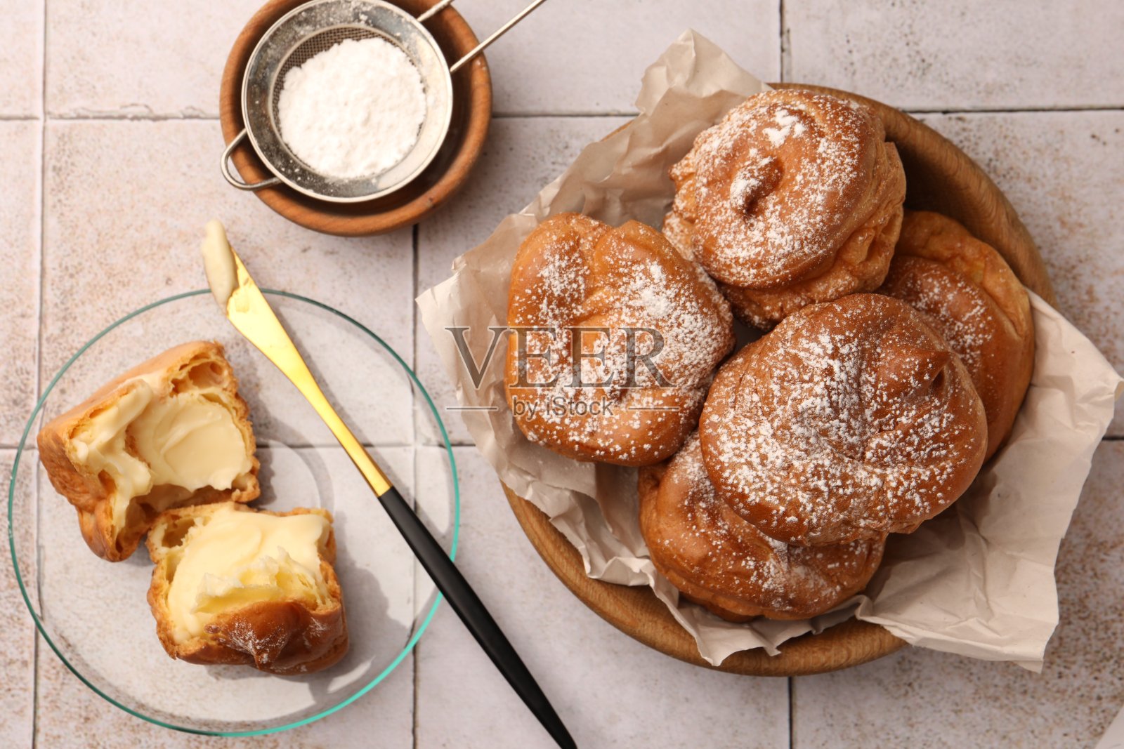 白色瓷砖的桌子上平铺着美味的奶油泡芙照片摄影图片