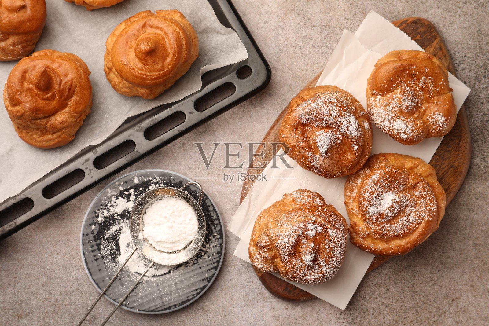 灰色的桌子平铺着美味的糖粉泡芙照片摄影图片