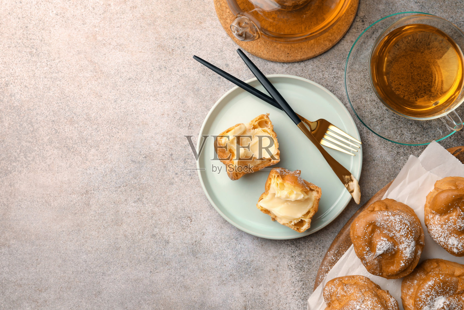 灰色的桌子平放着美味的奶油和茶泡芙。文本空间照片摄影图片