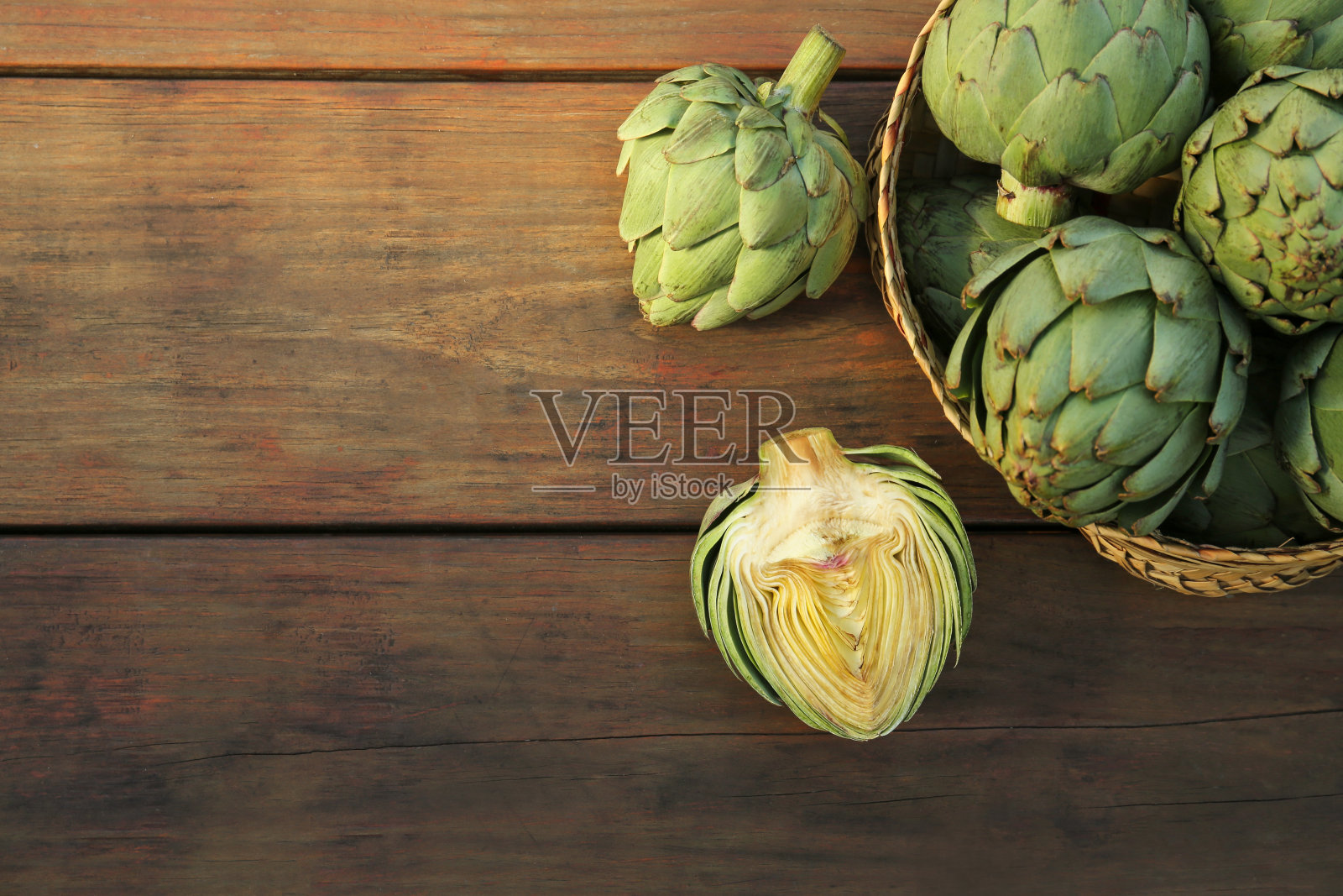 整棵切碎的新鲜生洋蓟放在木桌上，平放。文本空间照片摄影图片