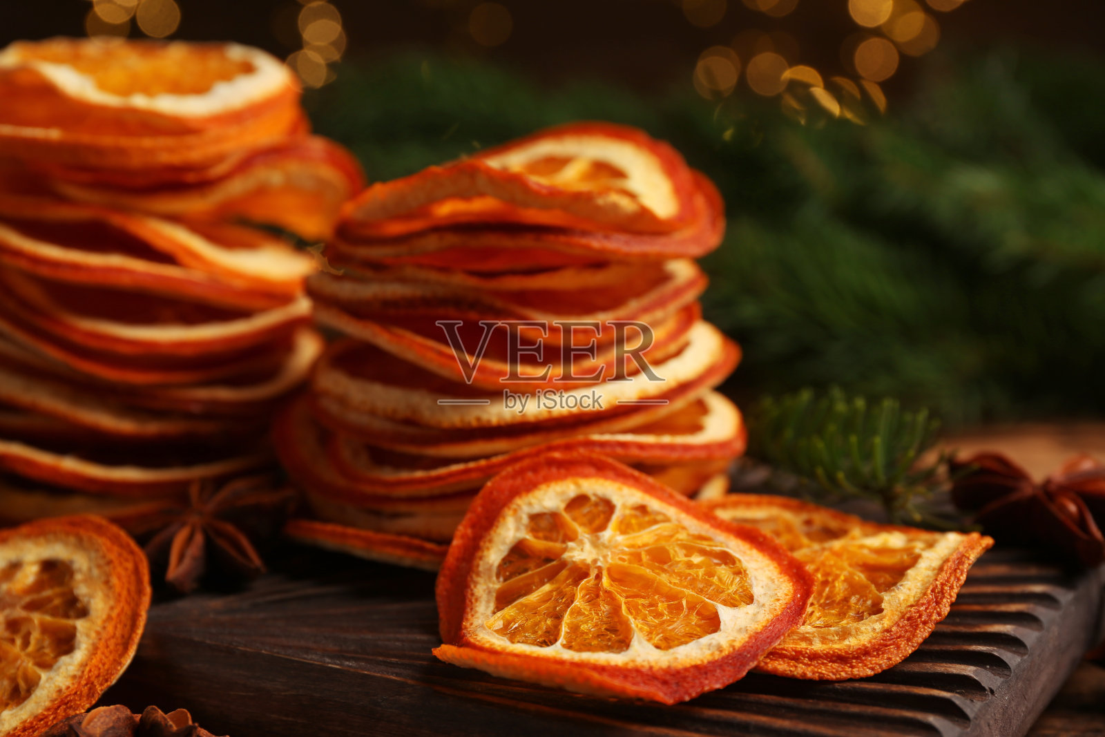 木板上的干橙片和八角，特写。散景效果照片摄影图片