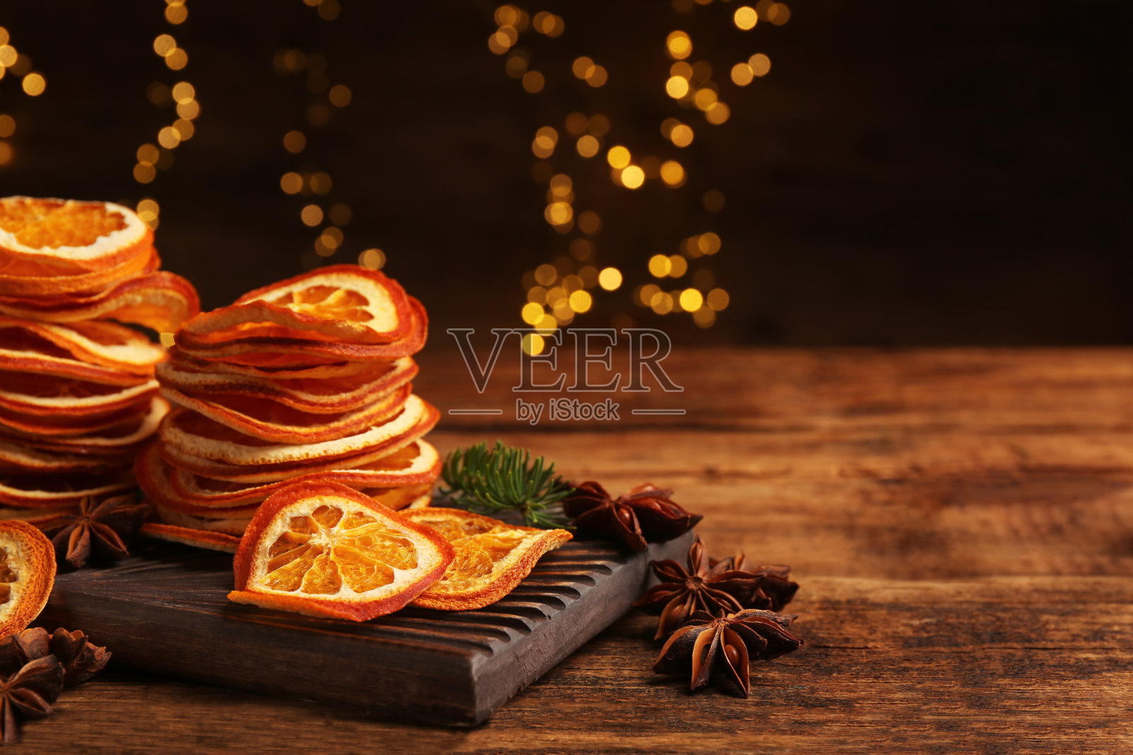 干橙片和八角星在木桌上，文字的空间。散景效果照片摄影图片