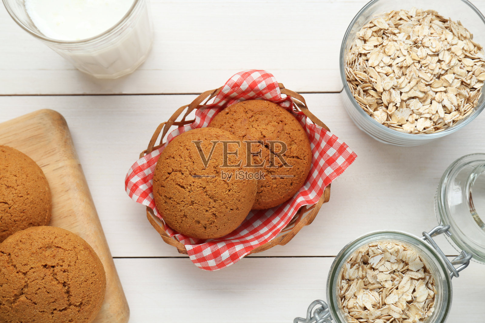 美味的燕麦饼干、燕麦片和牛奶平摊在白色的木桌上照片摄影图片