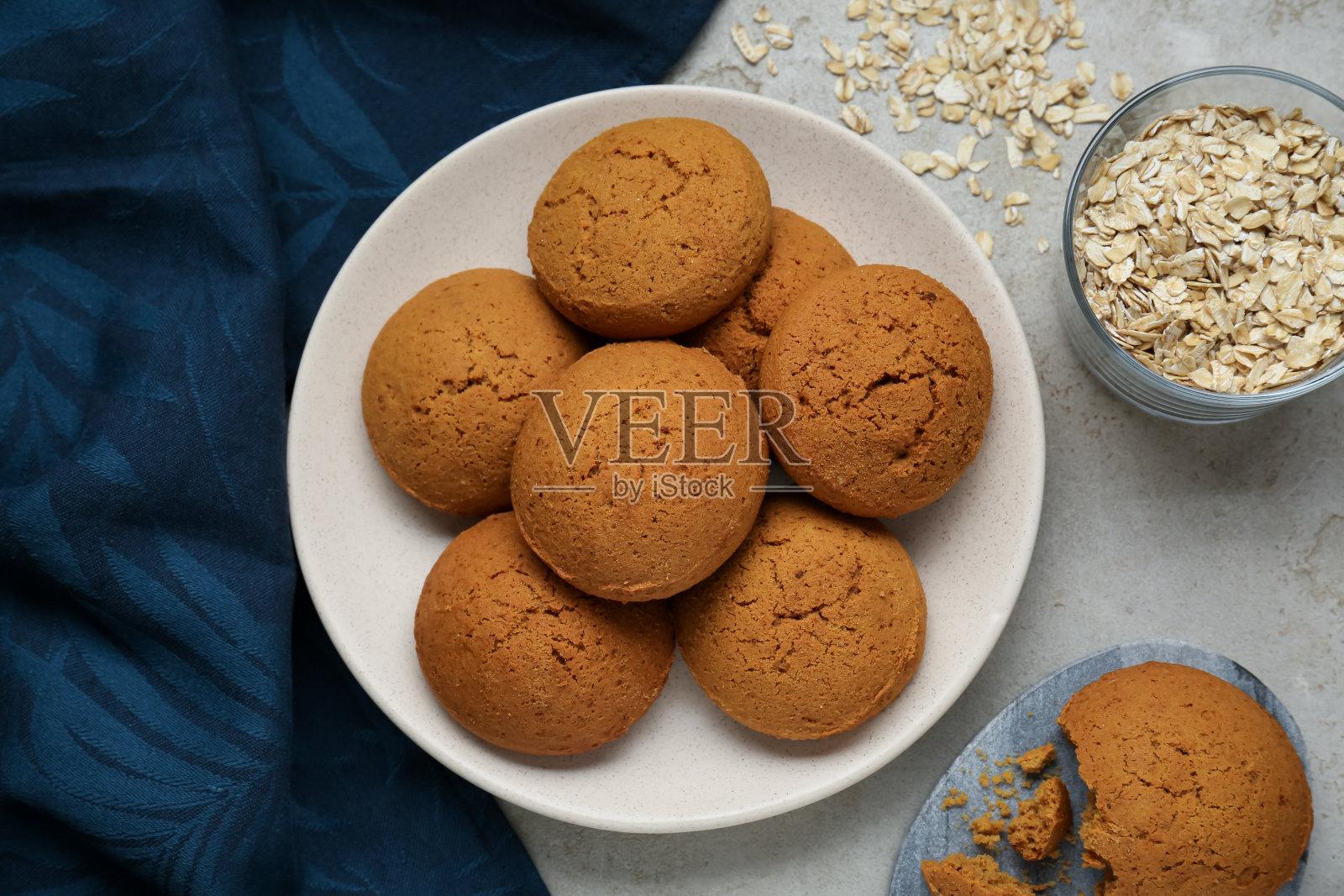 浅灰色的桌子上平躺着美味的燕麦饼干和燕麦片照片摄影图片