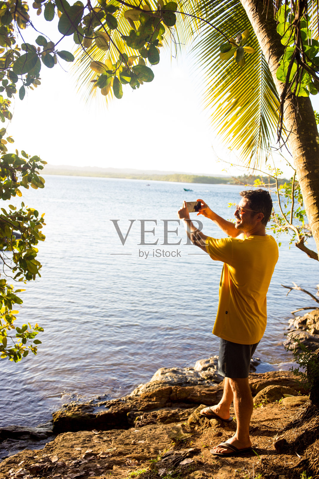 一名男子微笑着拍摄海滩地平线照片摄影图片