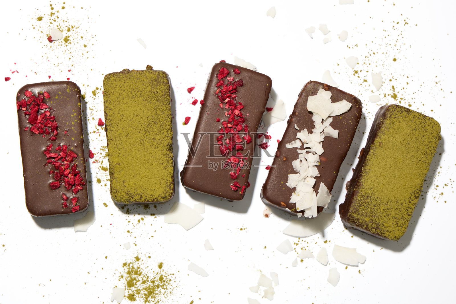 健康的素食棒，在白色的背景上有角豆和干果照片摄影图片