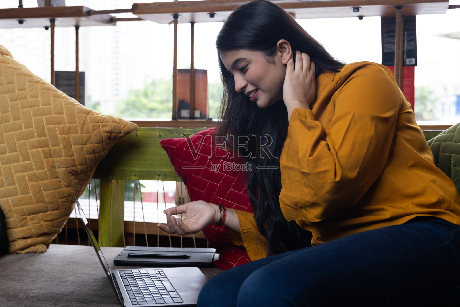 一个漂亮的年轻女孩，商业女性或学生坐在沙发上开会，在学校或大学图书馆或公司办公室照片摄影图片