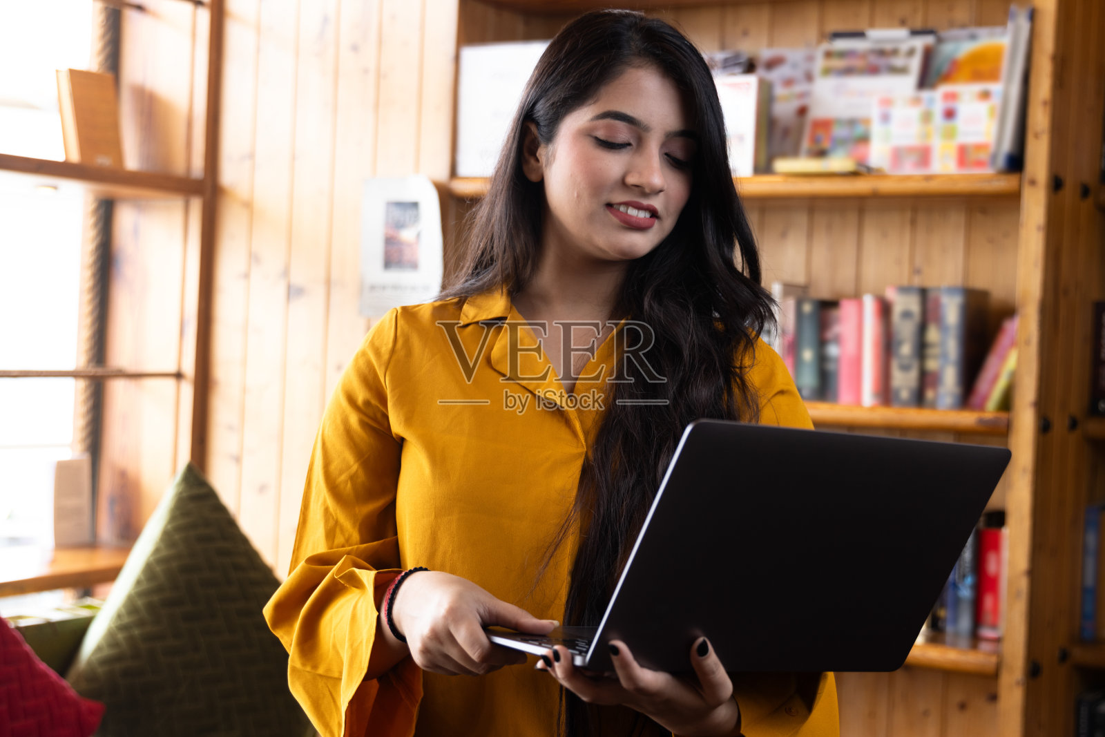 漂亮的年轻女商人，在学校或大学图书馆的笔记本电脑上学习或解释视频电话，或在公司办公室工作，在互联网或书籍上搜索信息照片摄影图片