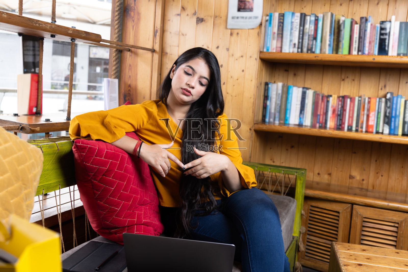 一个漂亮的年轻女孩，商业女性或学生坐在沙发上开会，在学校或大学图书馆或公司办公室照片摄影图片