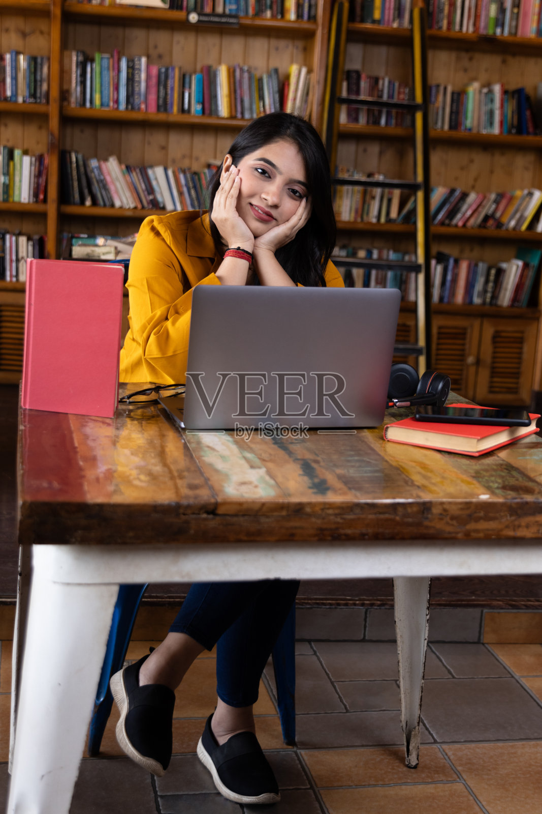 一个年轻的商业女性或女孩或学生工作或学习在学校或大学图书馆咖啡厅或公司办公室使用笔记本电脑照片摄影图片