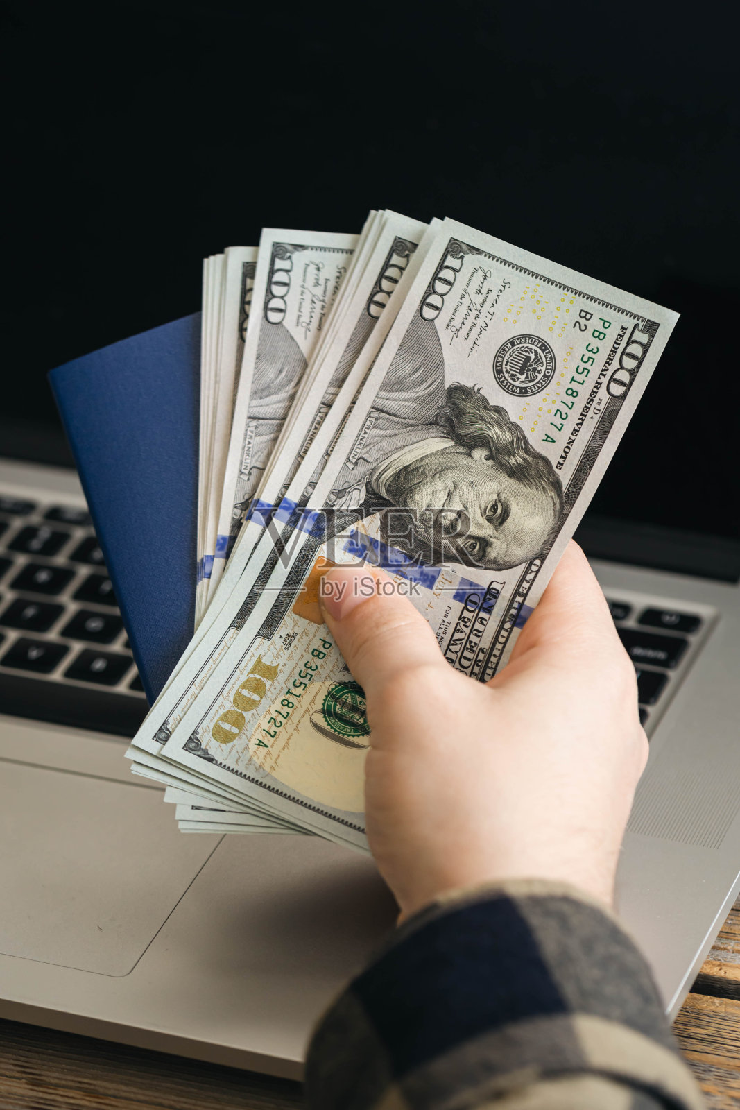 乌克兰生物识别护照和一名男子手里的美钞。照片摄影图片