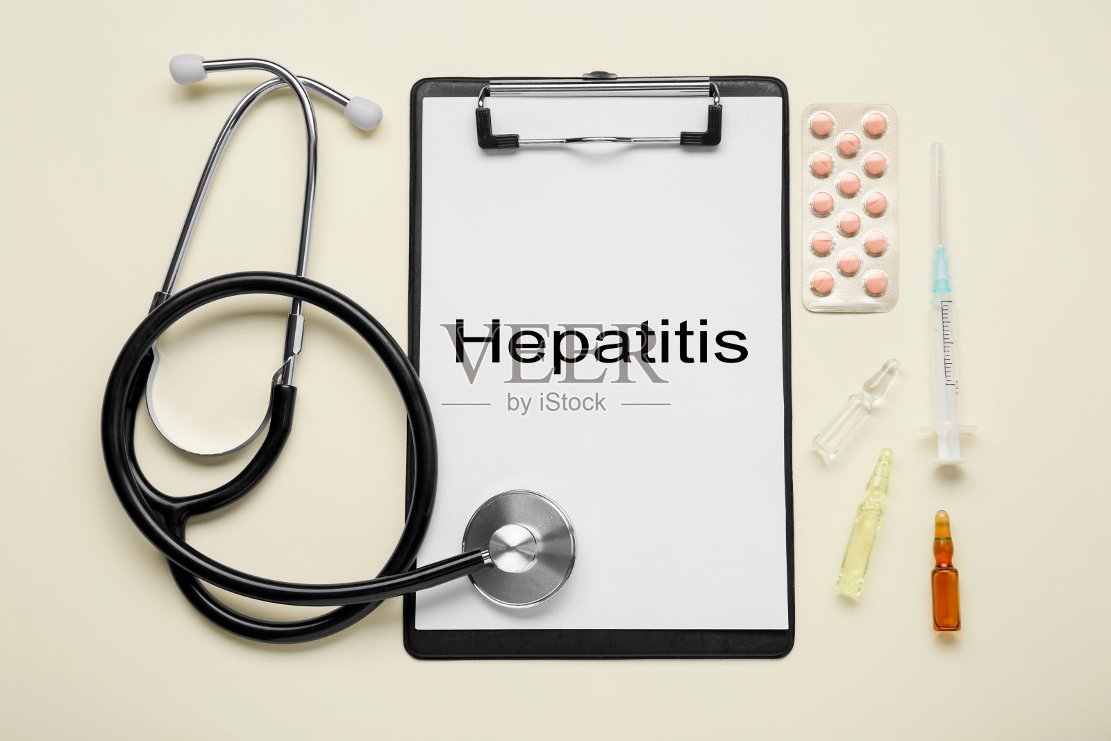 米色背景上写着肝炎和医疗用品的剪贴板，平铺照片摄影图片