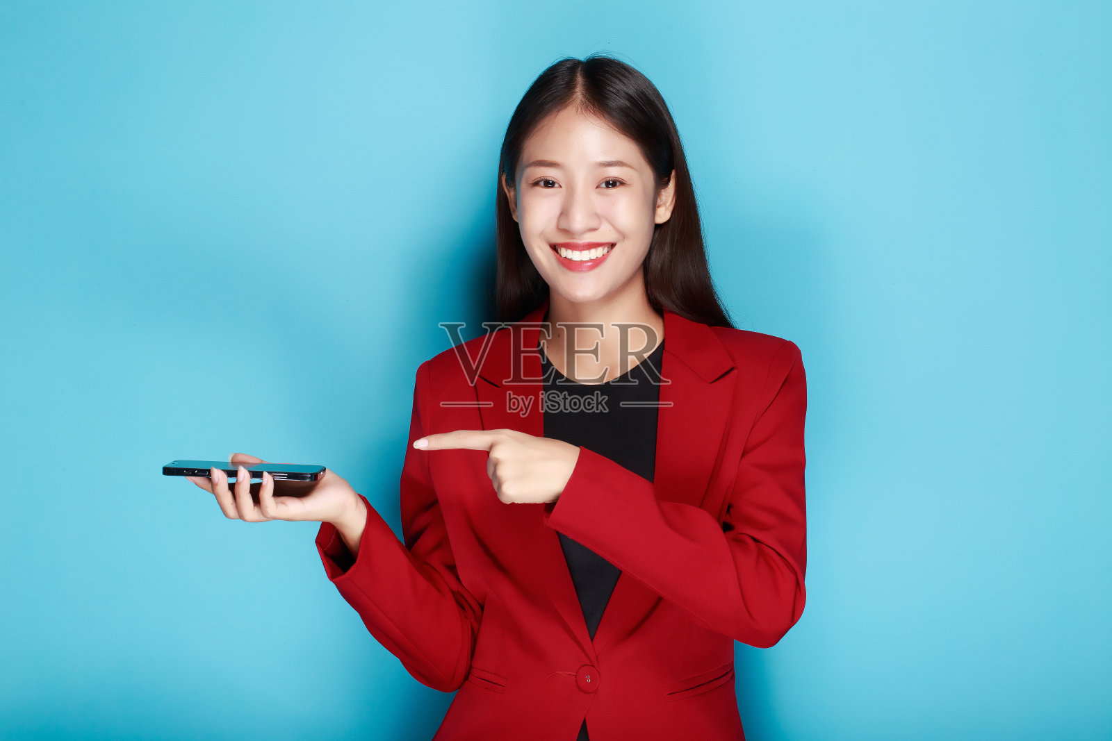 一个美丽的年轻女子的肖像在浅蓝色的背景下，美丽的女孩在红色的背景下，展示了手指的姿势。照片摄影图片