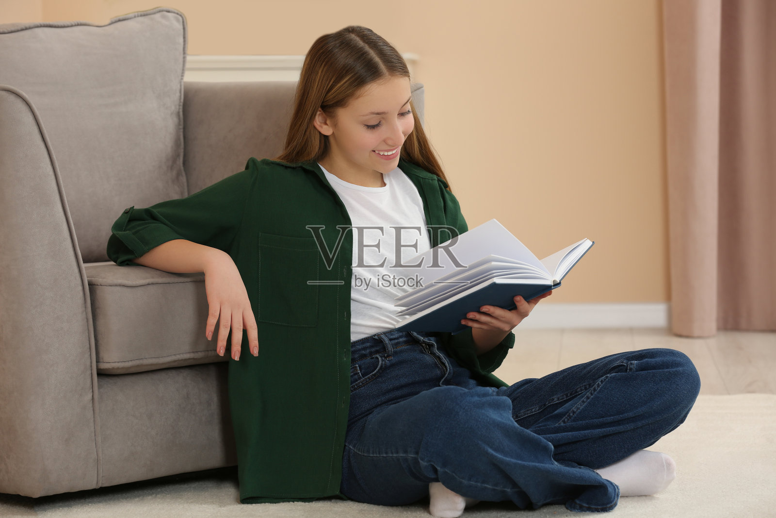 十几岁的女孩在房间的地板上看书照片摄影图片