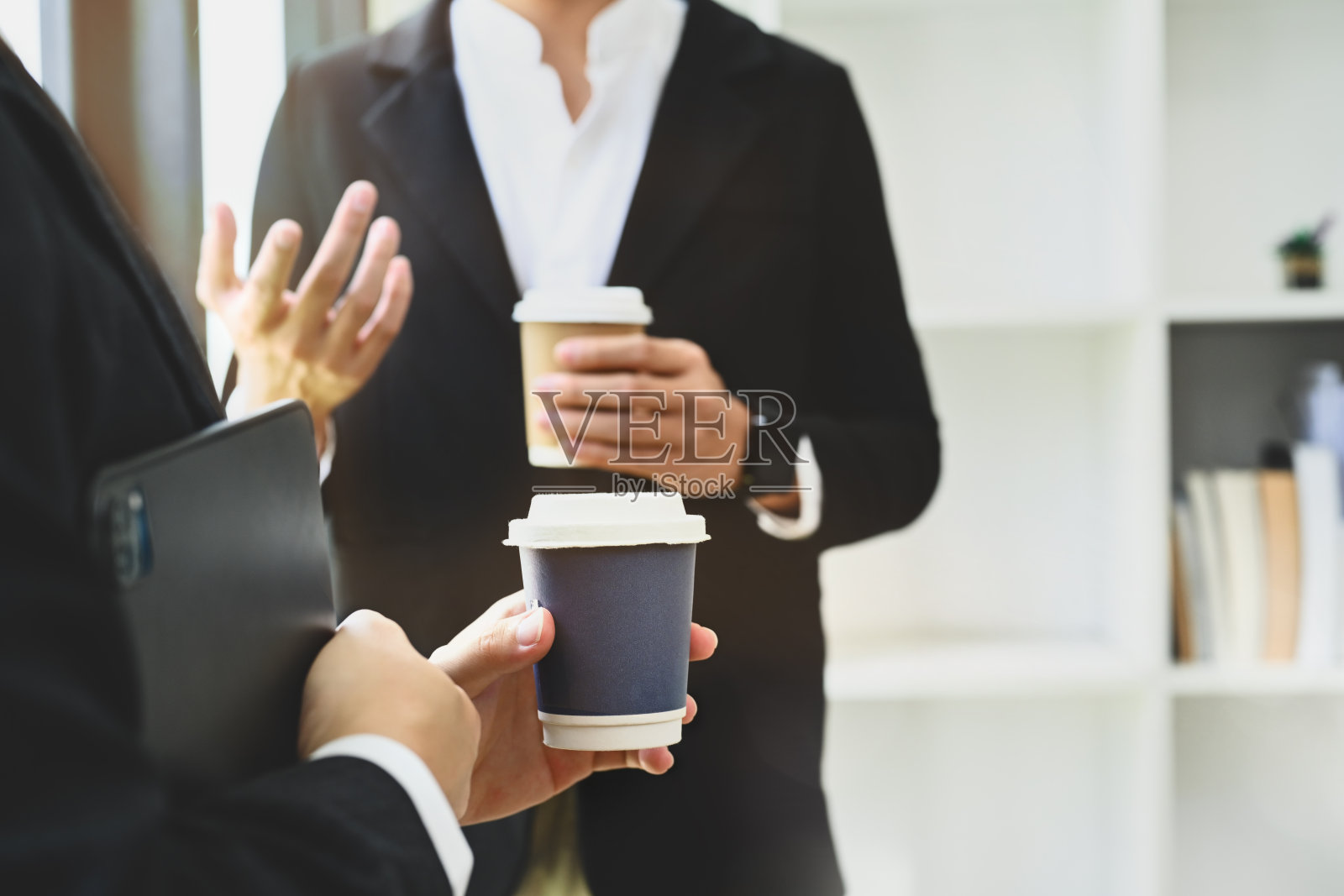 商务人士站在现代办公室里喝咖啡休息时讨论新想法照片摄影图片