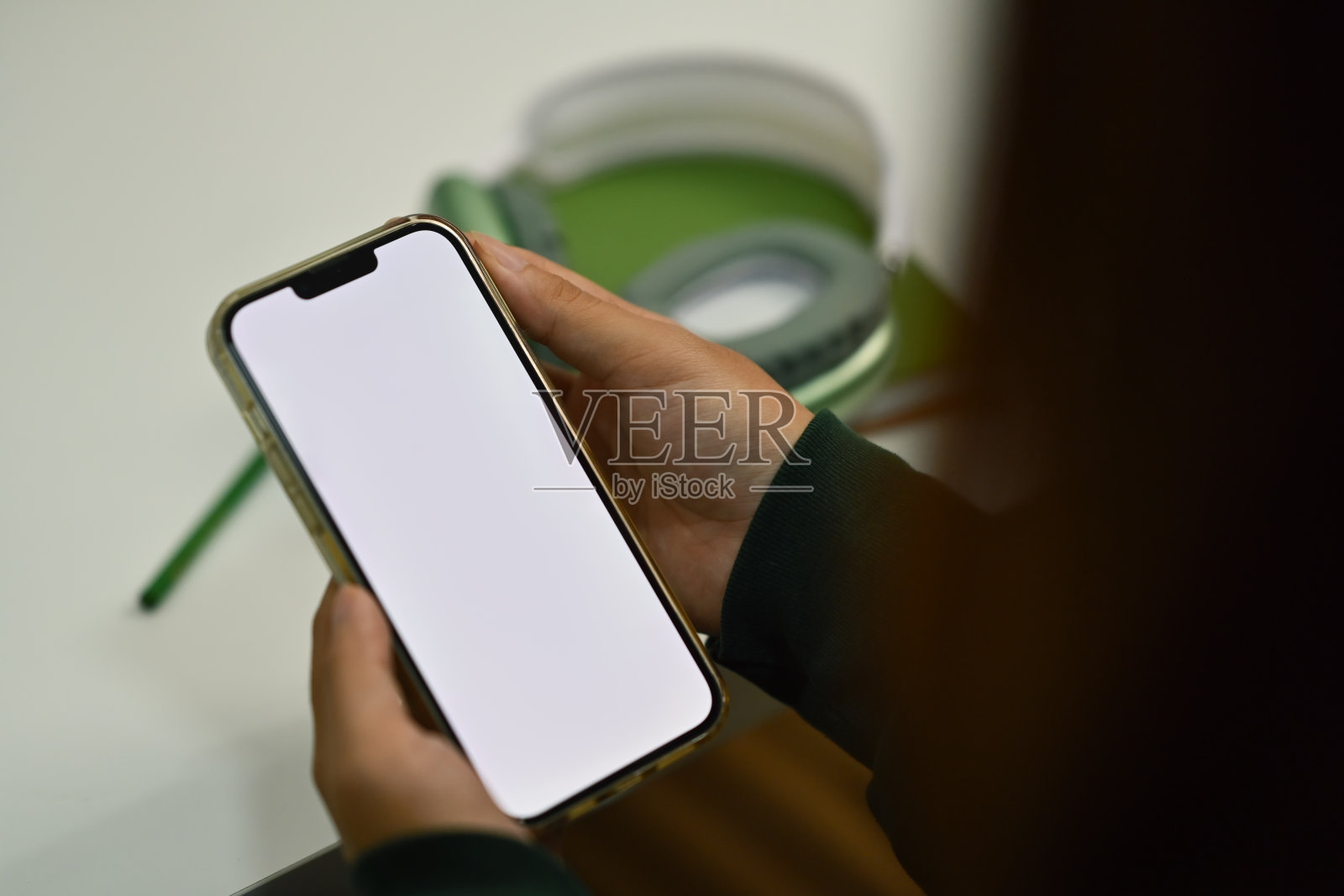 女士在办公桌旁使用手机。白色屏幕为您的广告短信照片摄影图片