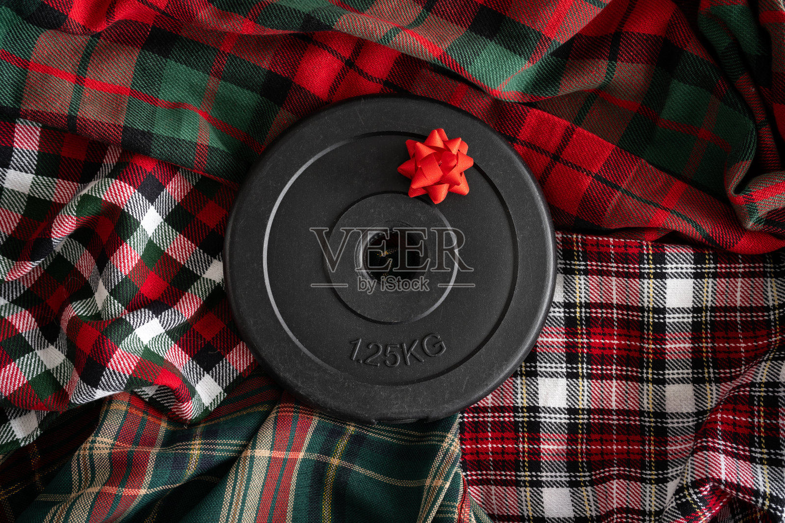 哑铃杠铃重量板带红弓。把健身器材作为圣诞礼物。健身房锻炼身体，运动训练平躺。照片摄影图片