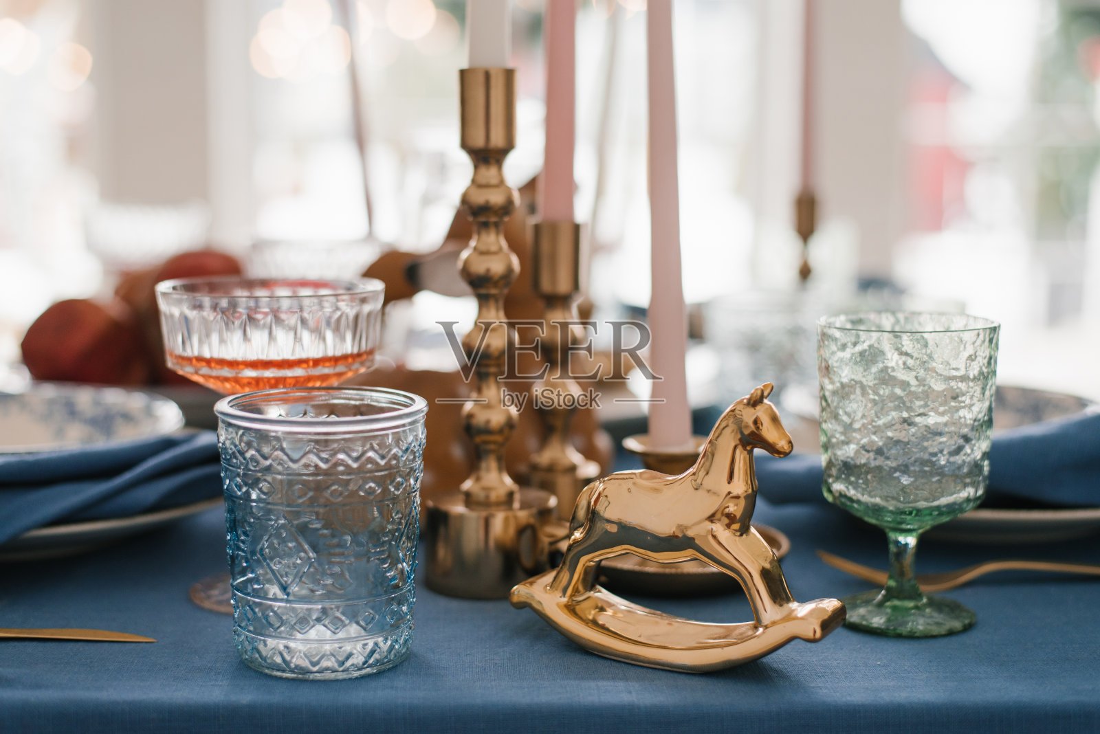 古董马，玻璃酒杯和烛台在圣诞餐桌的节日设置照片摄影图片