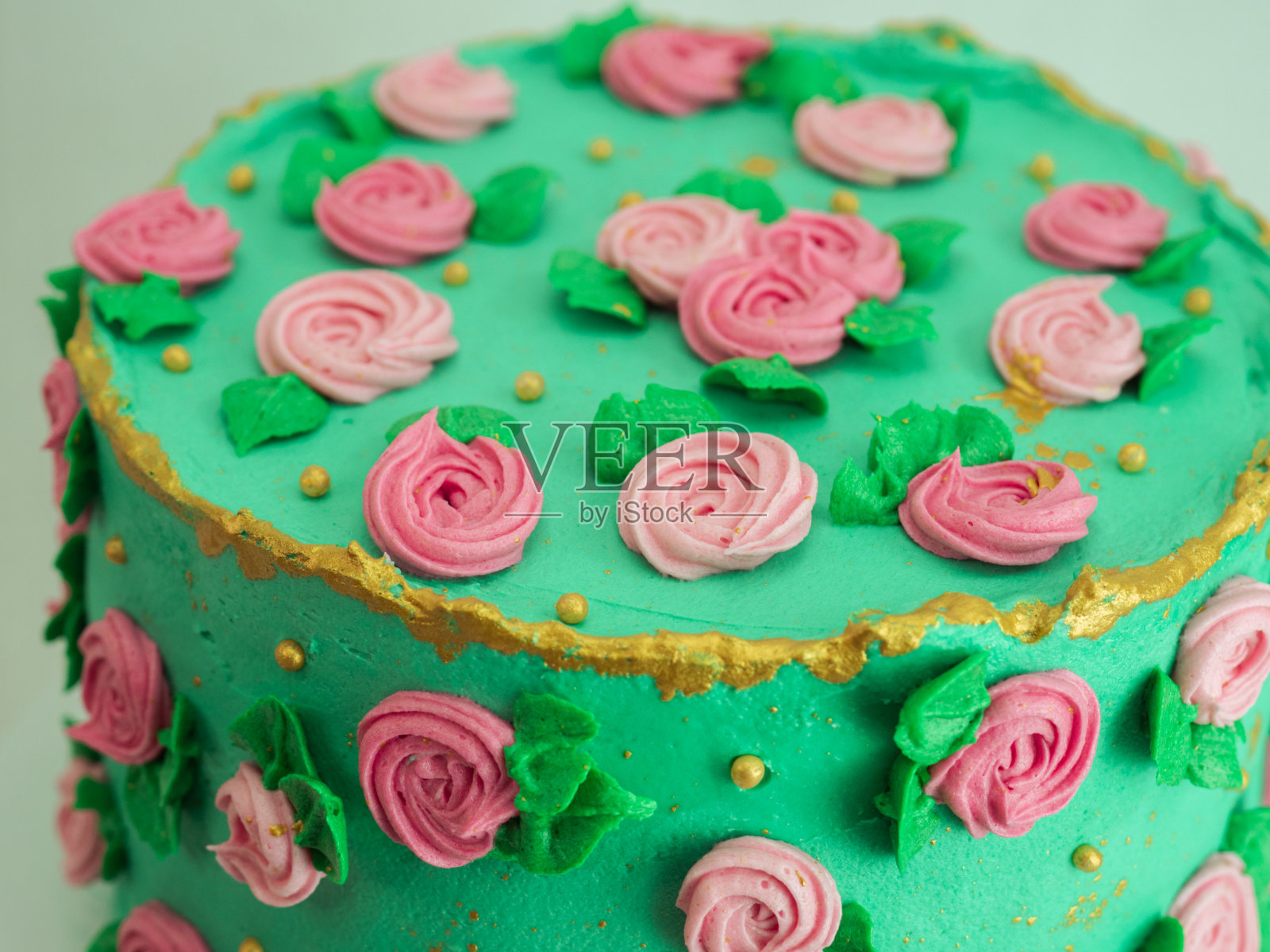绿色糖霜蛋糕，糖糊玫瑰和珍珠点缀四周的形状照片摄影图片