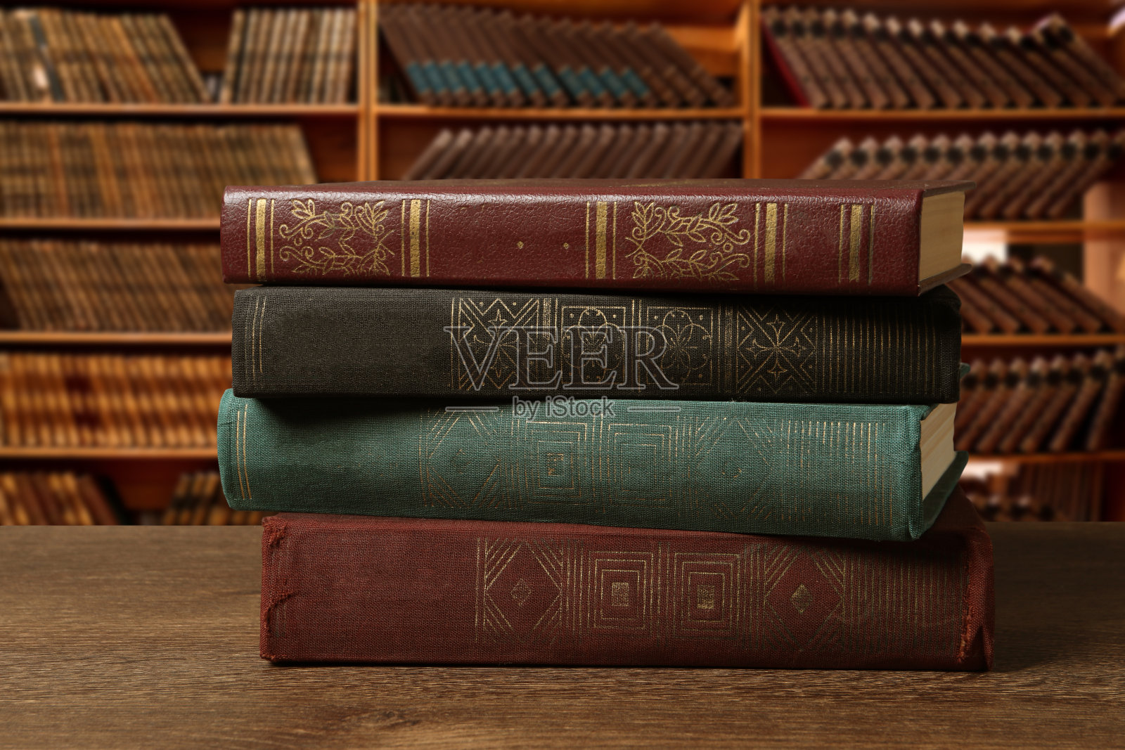 图书馆的木桌上堆放着许多精装书照片摄影图片