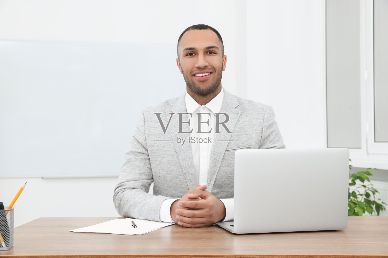 快乐的年轻实习生在现代办公室的餐桌上工作照片摄影图片