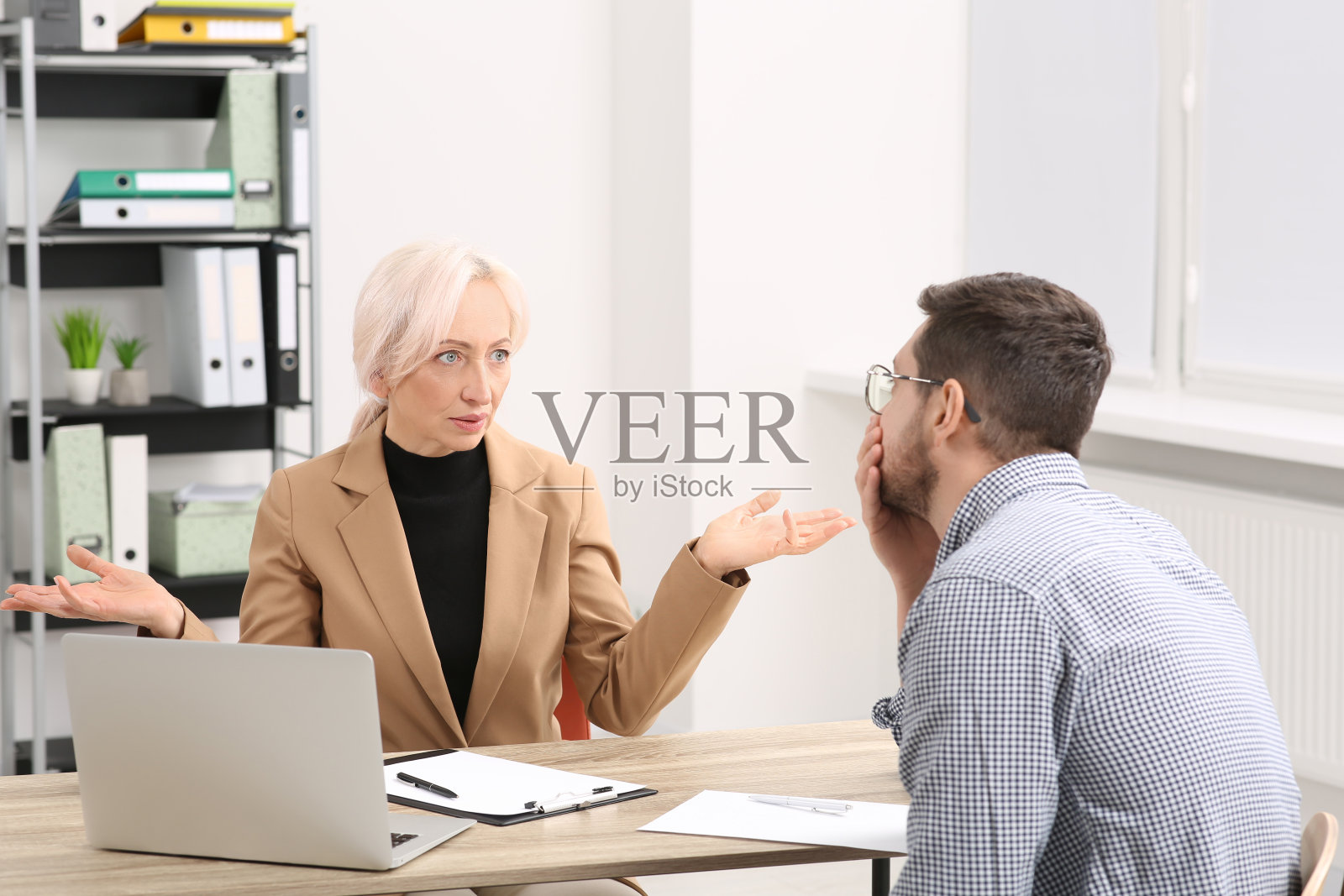 老板和压力大的员工在办公室的木桌边讨论工作问题照片摄影图片