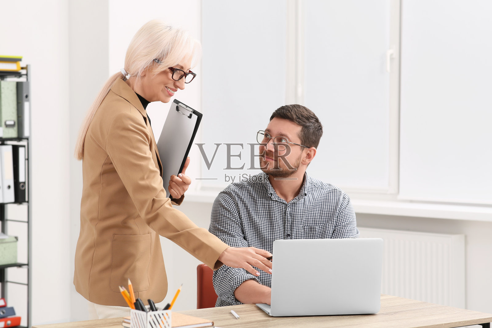 老板和员工拿着笔记本电脑在办公室讨论工作问题照片摄影图片