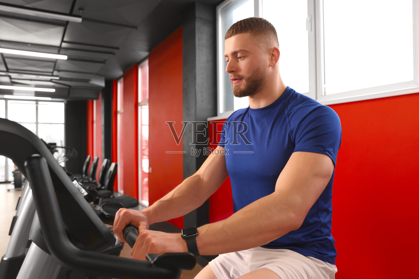 男子在健身房里骑自行车训练照片摄影图片