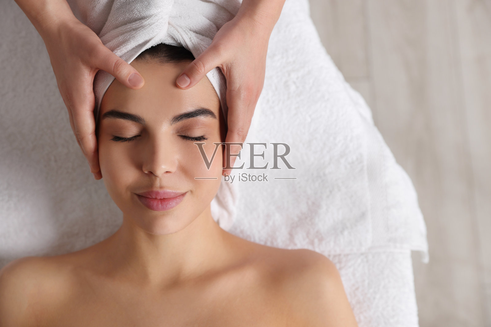 美女在美容院接受面部按摩，特写。俯视图照片摄影图片