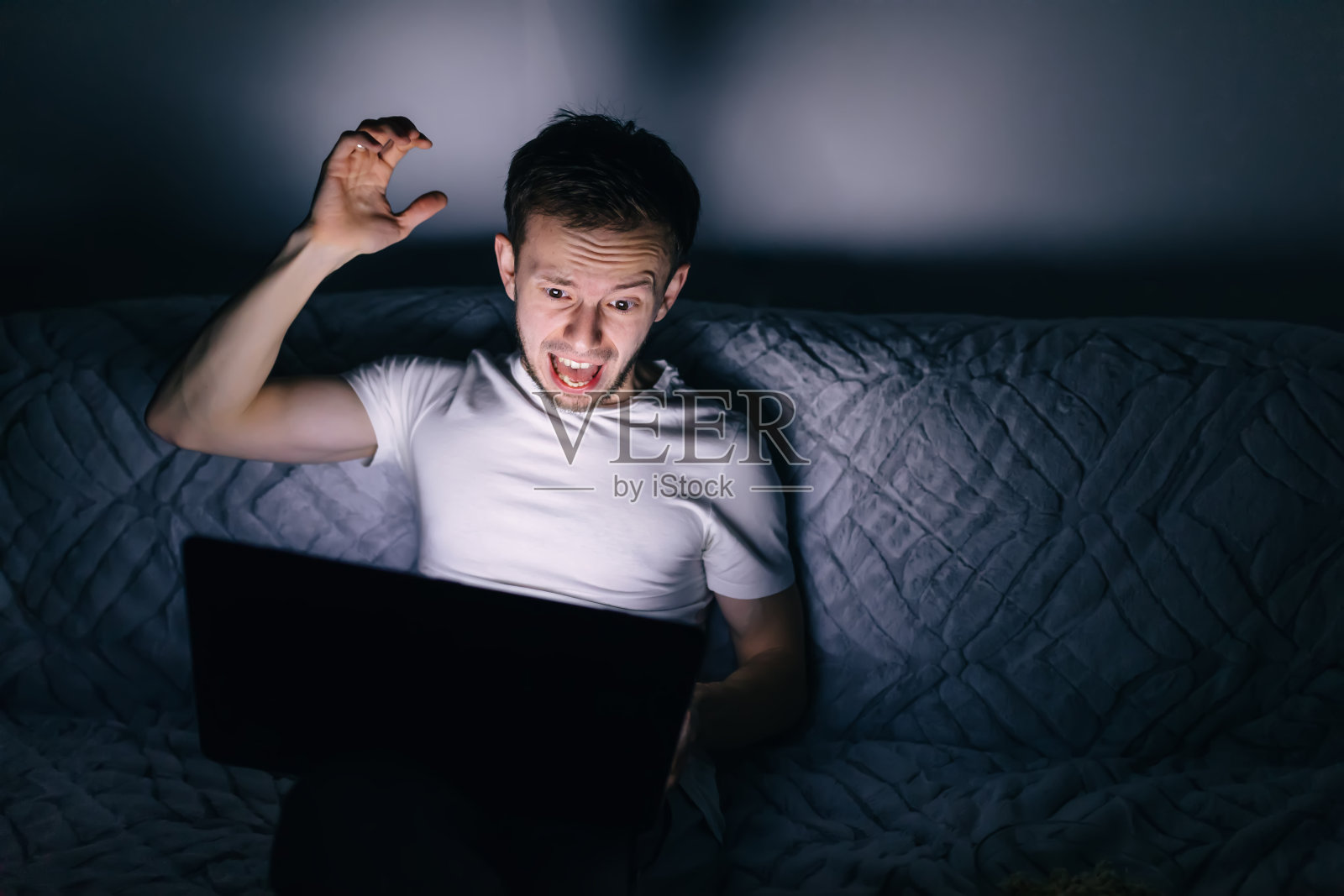 男球迷在他的笔记本电脑上观看足球直播，照片摄影图片