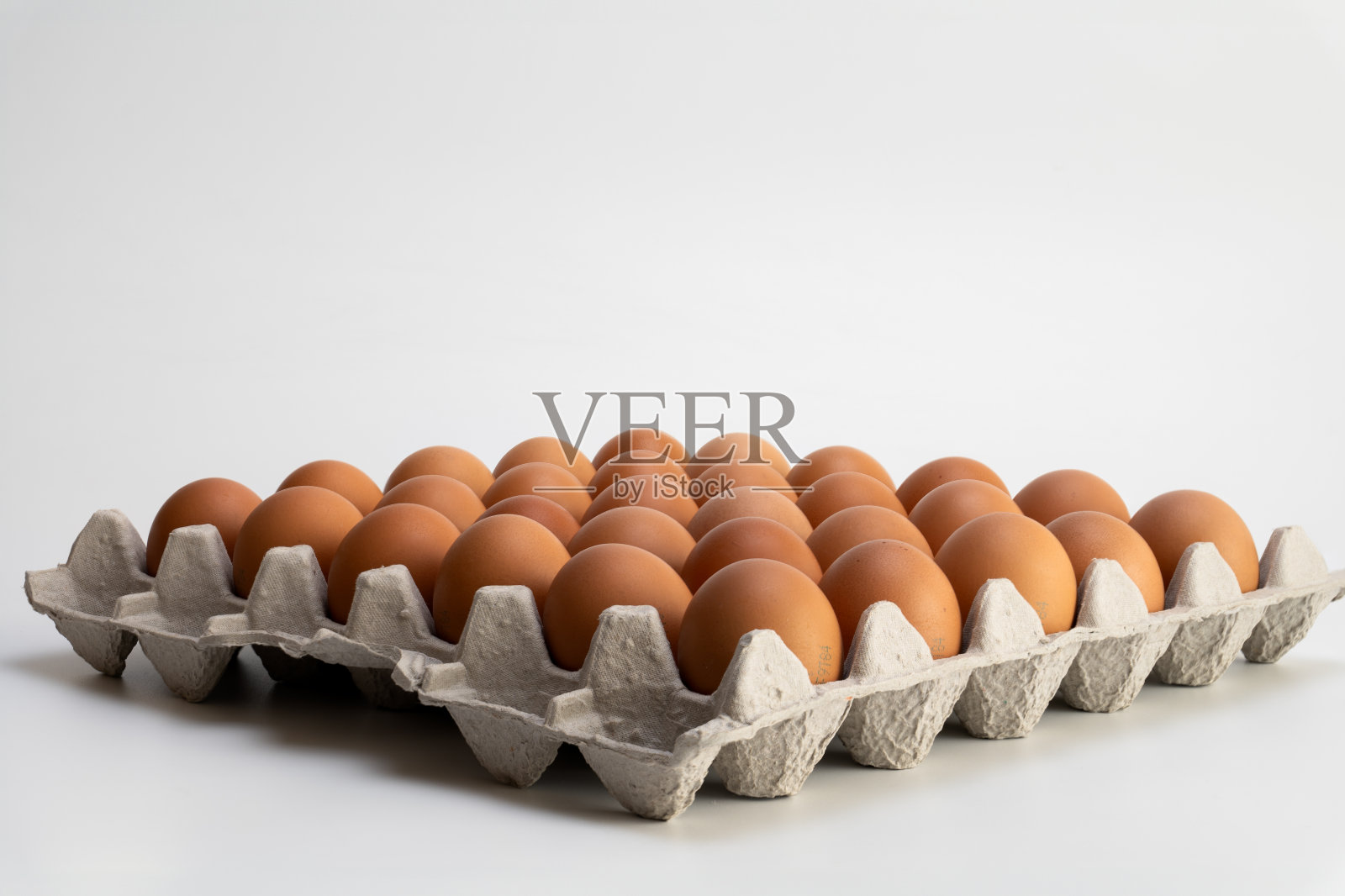 白色背景的纸板箱里的棕色鸡蛋照片摄影图片