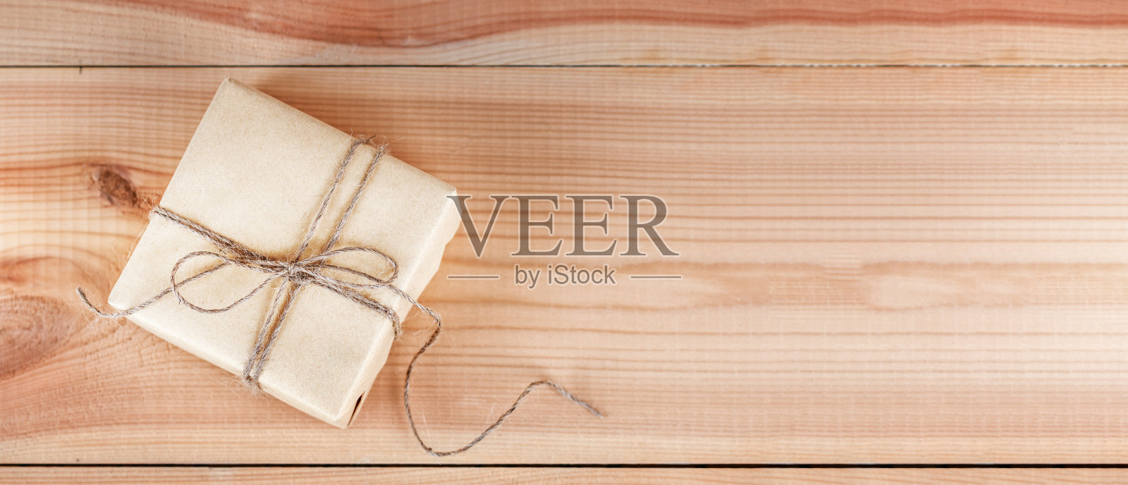 木桌上用牛皮纸包裹着贺词的礼盒俯视图。模拟的复制空间照片摄影图片