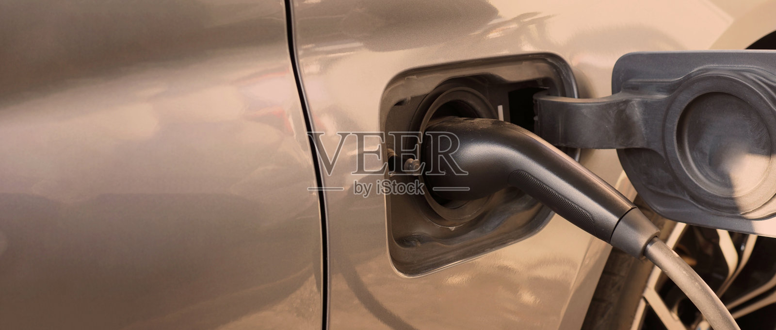 电动汽车或电动汽车停放在充电站和插头电缆供电。为电动汽车或混合动力汽车电池充电。世界未来交通的绿色能源和生态动力。电动汽车动力照片摄影图片