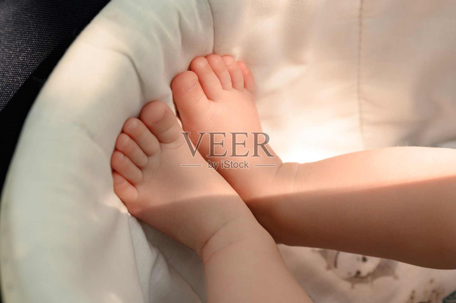 婴儿的双腿靠在婴儿车的侧面。照片摄影图片