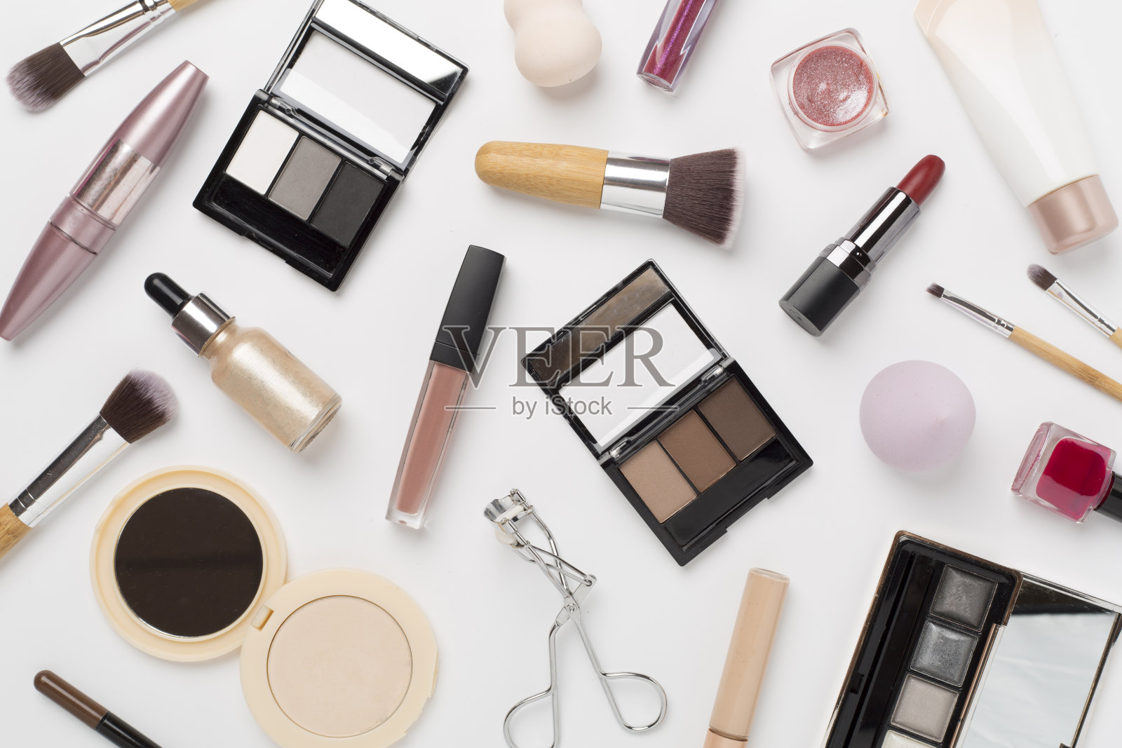 用彩妆产品和工具平躺在彩色背景上照片摄影图片